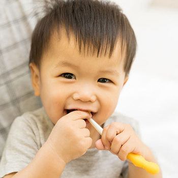 asian baby with toothbrush